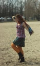 Happy red-haired young girl in bright hippie clothes in orange tights posing and laughing happily whirling and jumping