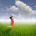 Happy red woman jumping in green rice fields and clouds sky. Royalty Free Stock Photo