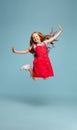 Happy redhair girl isolated on blue studio background. Looks happy, cheerful, sincere. Copyspace. Childhood, education