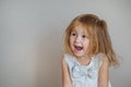 Happy redhair girl in white dress on light gray background