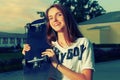 Happy redhair teen girl posing with skateboard