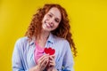 Happy redhead ginger curly girl businesswoman in a cotton shirt model hold decorative hearts Valentines Day gift on Royalty Free Stock Photo