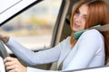 Happy redhead girl talking on her mobile phone behind the wheel driving a car Royalty Free Stock Photo