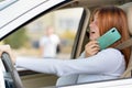 Happy redhead girl talking on her mobile phone behind the wheel driving a car Royalty Free Stock Photo