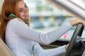 Happy redhead girl talking on her mobile phone behind the wheel driving a car Royalty Free Stock Photo