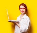 Happy redhead girl in white shirt with computer Royalty Free Stock Photo