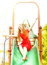 Happy redhead woman on a children slide