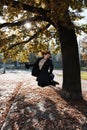 Happy redhead woman throwing and playing with autumn leaves starting fresh new life in Prague