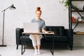 Happy redhead young woman student noting into the workbook important information from book Royalty Free Stock Photo