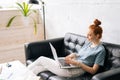 Happy redhead young woman using laptop at home sitting on soft couch Royalty Free Stock Photo