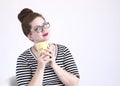 Happy redheaded woman loves her coffee and hold the cup close to her face with a smile in the studio on a white background