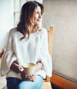 Happy, relax and woman drinking coffee while daydreaming in her home, calm and quiet on wall background. Tea Royalty Free Stock Photo