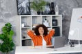 Happy relaxed african american young woman rest in chair distracted from computer work, relieve negative emotions Royalty Free Stock Photo