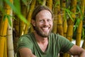 Happy, relaxed bearded man in bamboo garden