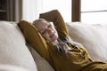 Happy relaxed beautiful mature woman resting on home sofa Royalty Free Stock Photo