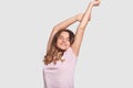 Happy relaxed Caucasian woman stretches after awakening, being in good mood as saw pleasant dreams, dressed in nightwear, ready to Royalty Free Stock Photo