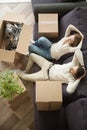 Happy relaxed couple resting on sofa with boxes, top view Royalty Free Stock Photo