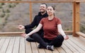 Happy relaxed man and woman doing yoga outdoors. Smiling sportsman sitting in lotus pose Royalty Free Stock Photo