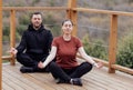 Happy relaxed man and woman doing yoga outdoors. Smiling sportsman sitting in lotus pose Royalty Free Stock Photo