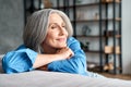 Happy relaxed mature old woman resting dreaming sitting on couch at home. Royalty Free Stock Photo