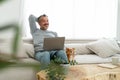Happy relaxed Middle aged Caucasian man relaxing sitting on couch with his chihuahua dog lying besides are looking at something Royalty Free Stock Photo