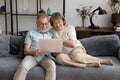 Happy relaxed middle aged couple sitting on couch at home Royalty Free Stock Photo
