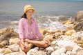 Happy relaxed woman meditation in lotus position practicing yoga sitting on stone beach sea waves Royalty Free Stock Photo