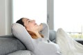 Happy relaxed woman resting on a couch at home Royalty Free Stock Photo