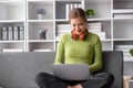 Happy and relaxed young Asian woman listening to music through her headphones on a sofa in her living room. Royalty Free Stock Photo