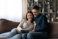 Happy relaxed young family couple using digital computer tablet. Royalty Free Stock Photo