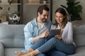 Happy relaxed young family couple using digital computer tablet. Royalty Free Stock Photo