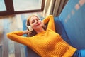 Happy relaxed young woman listening to music with wireless headphones with closed eyes lies on the couch at home Royalty Free Stock Photo