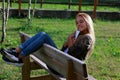 Happy relaxed young woman sitting on a park bench at sunset Royalty Free Stock Photo