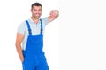 Happy repairman leaning on blank placard