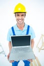 Happy repairman wearing hard hat while holding laptop Royalty Free Stock Photo