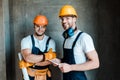 Repairmen in goggles and helmets standing in house Royalty Free Stock Photo