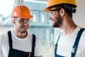 Repairmen in helmets and goggles looking at each other