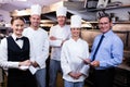 Happy restaurant team standing together in commercial kitchen