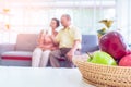 Retired asian couple reading book on a couch in living room with fresh fruit on the table to healthy eating and lifestyle Royalty Free Stock Photo