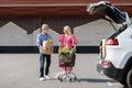 Happy retired man and woman rolling shopping cart with grocery Royalty Free Stock Photo