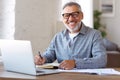 Happy retired pensioner learning studying online on laptop at home Royalty Free Stock Photo