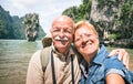 Happy retired senior couple taking travel selfie around world -