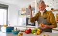 Happy retired senior man cooking in kitchen. Retirement, hobby people concept Royalty Free Stock Photo