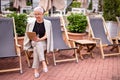 Happy retired woman sitting on the chair and looking at the camera Royalty Free Stock Photo