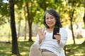 Happy retried woman making video call via smart phone while relaxing in suburb house courtyard Royalty Free Stock Photo