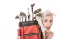 Happy retro girl peeking out from behind red golf bag, isolated Royalty Free Stock Photo