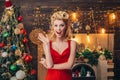 Happy retro woman over Christmas interior background. Colorful makeup and retro hairstyle for Christmas or new year