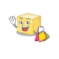 A happy rich creamy butter waving and holding Shopping bag