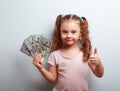 Happy rich kid girl holding money and showing thumb up sign Royalty Free Stock Photo