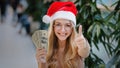 Happy rich successful Caucasian woman in red Santa Christmas hat cap and eyeglass holding money dollars counting cash Royalty Free Stock Photo